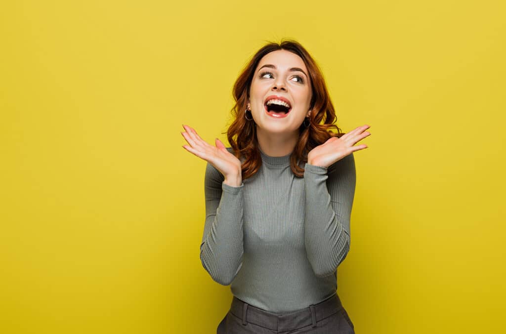 Happy woman on yellow background.